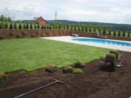 Pokládka travních koberců na ploše okolo bazénu na zahradě v Letkově